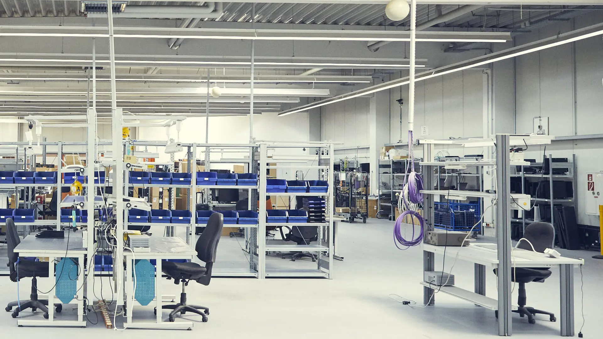 Servicehalle in Heiligenhaus mit Werkbänken und Regalen mit blauen Kleinteilkästen